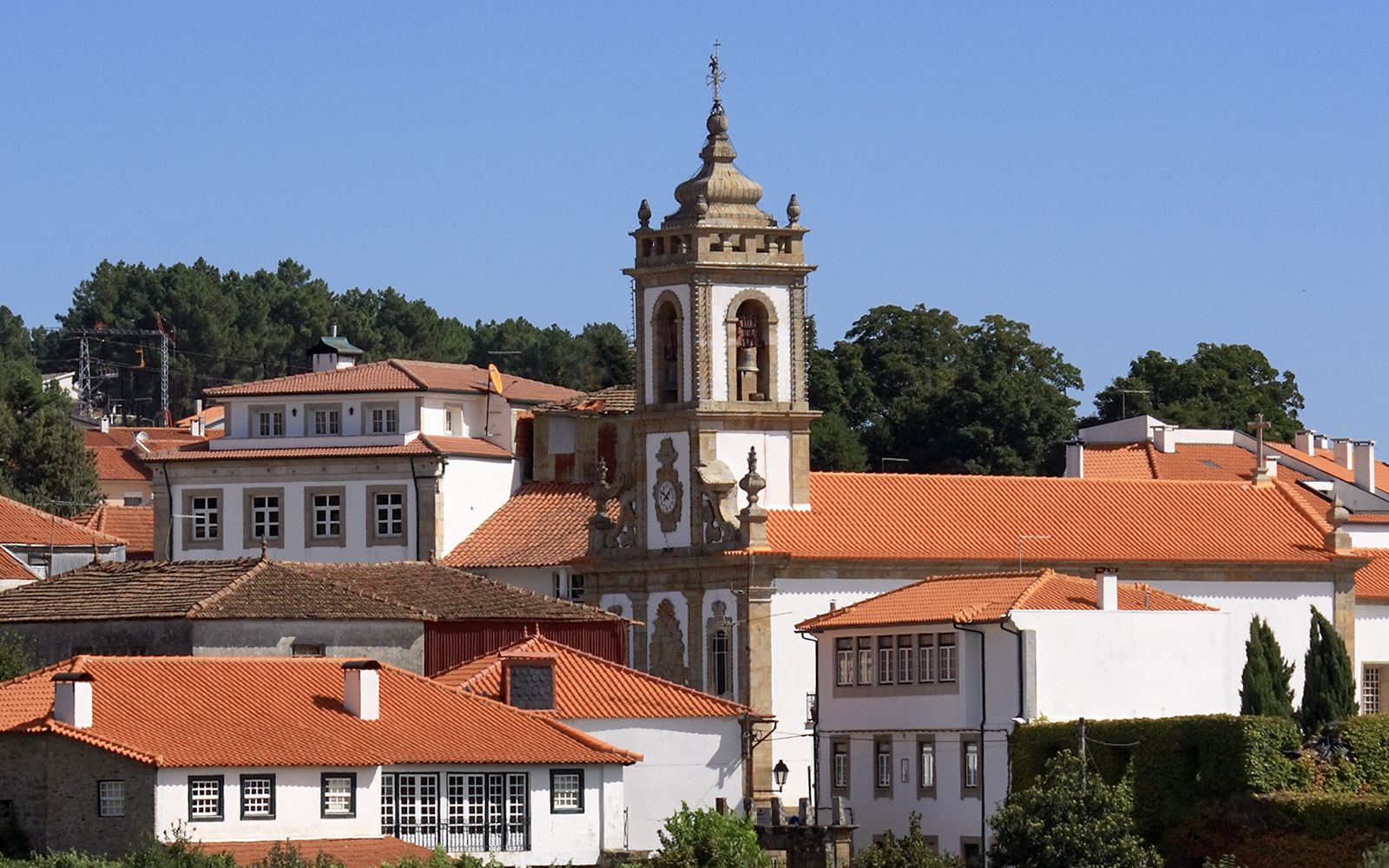 Parish church tower with red-tiled roofs in Sabrosa, Portugal.
