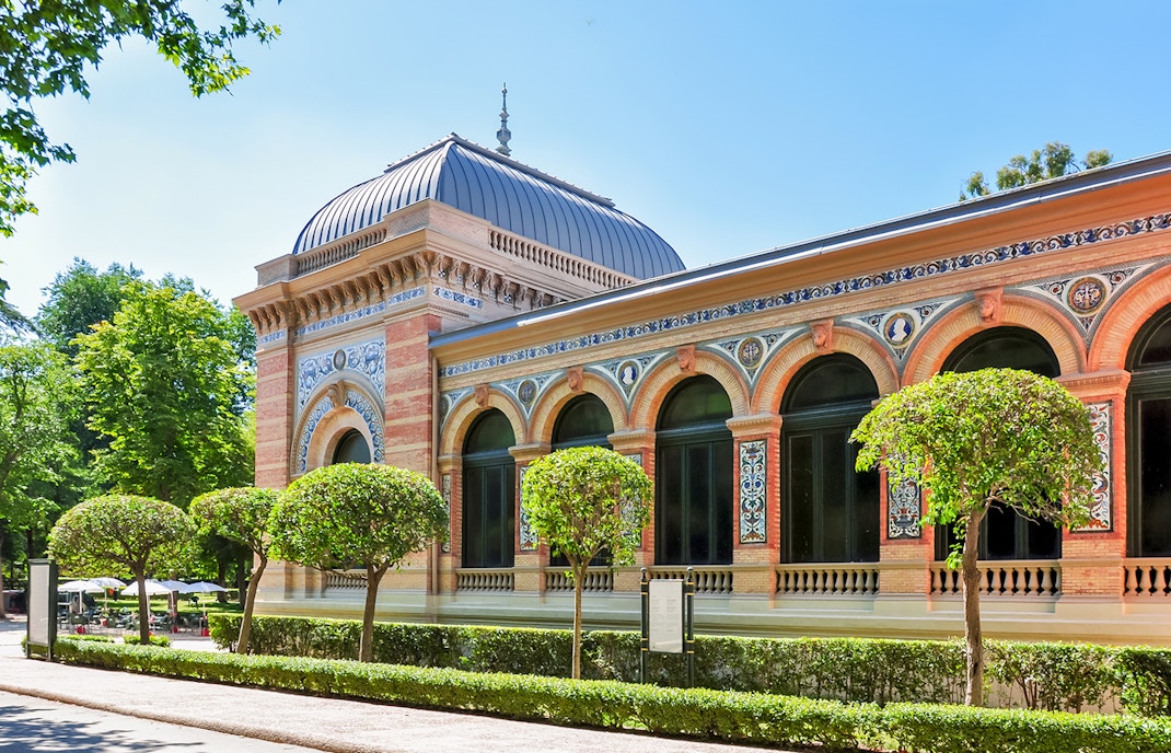 Velazquez Palace in Madrid with ornate facade and lush garden.