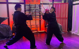 Ninjas practicing sword techniques in an Osaka dojo during a workshop.