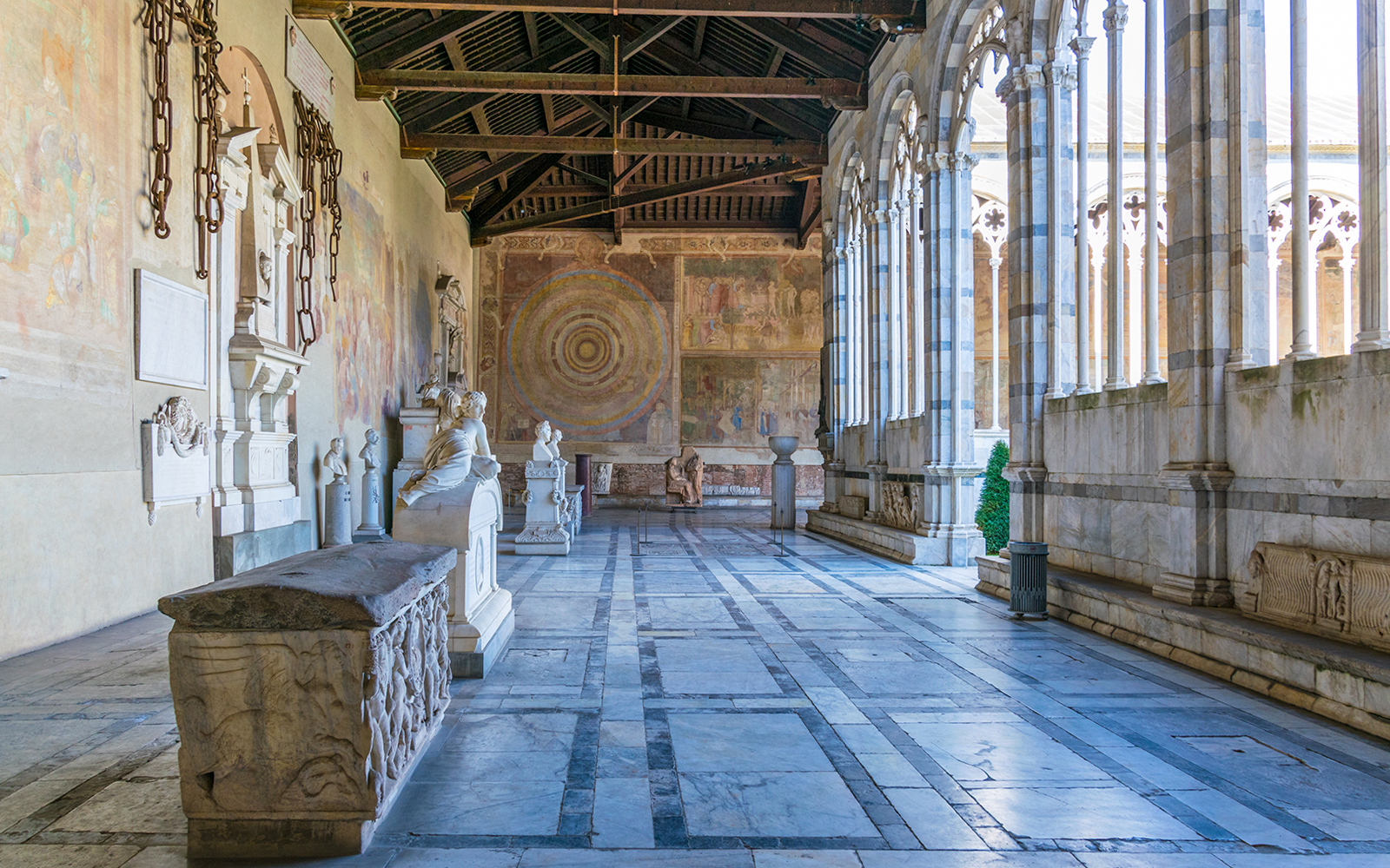 Pisa Camposanto interior with sculptures and frescoes, located in Pisa Cathedral Square.