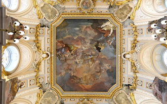 Ceiling fresco and ornate details in the Royal Palace of Madrid during a guided tour.
