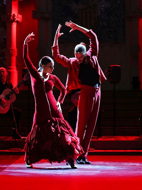 Flamenco dancers performing at Palau de la Música, Barcelona, with guitarists in the background.