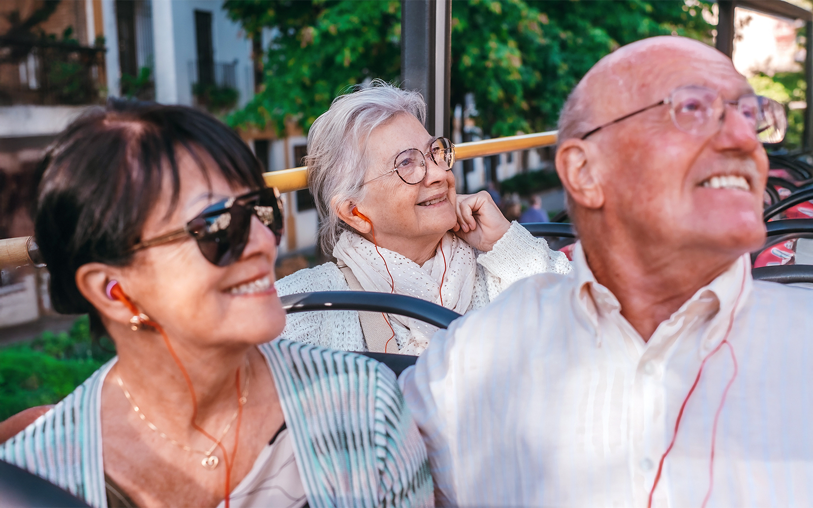 Tourists using an audio guide on an open-top bus tour in Valletta, Malta.
