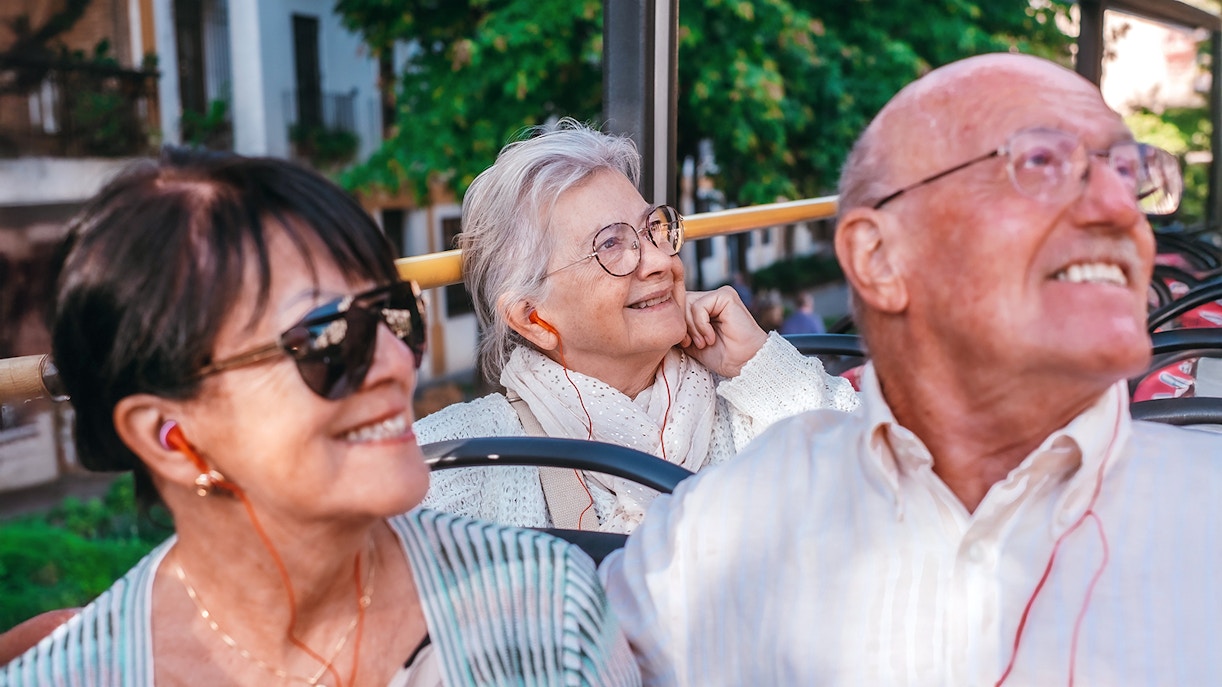 Touristes utilisant un audioguide lors d'une visite en bus à toit ouvert à La Valette, Malte.