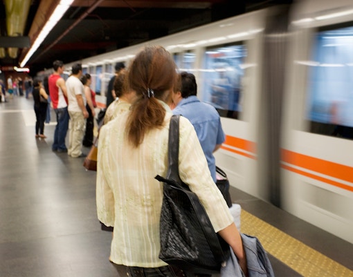 Rome metro station platform with passengers boarding a train.