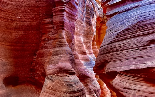 Antelope Canyon X sandstone formations with vibrant colors and light patterns.