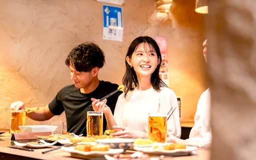 Dining experience in Asakusa with friends enjoying food and drinks, part of Senso-ji Temple audio tour.