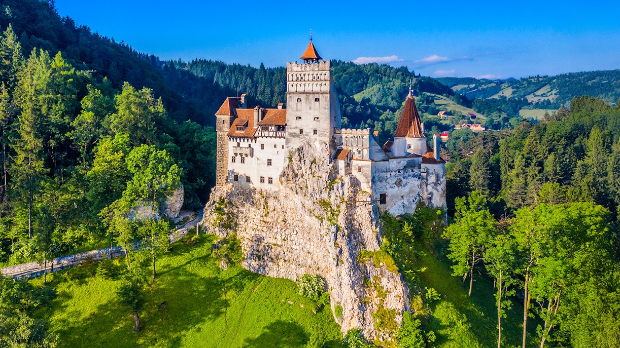 Bran Castle surrounded by lush green forest in Transylvania, Romania.