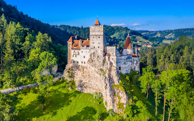 Bran Castle surrounded by lush green forest in Transylvania, Romania.
