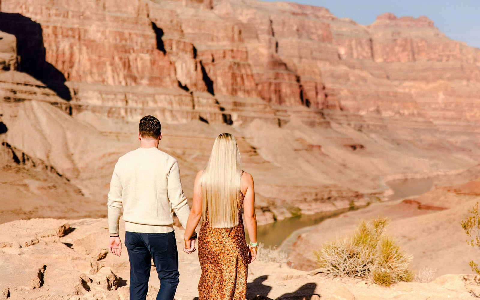 Grand Canyon West Rim helicopter tour guests walking on canyon floor near Las Vegas.