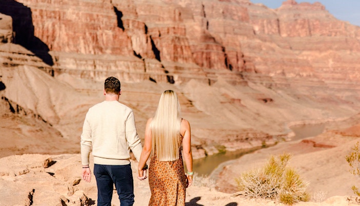 Grand Canyon West Rim helicopter tour guests walking on canyon floor near Las Vegas.