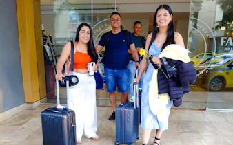 Travelers with luggage outside a hotel in Panama City, ready for airport transfer.