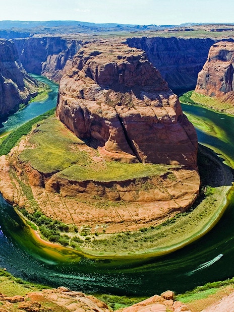 Aerial view of Horseshoe Bend with Colorado River, part of a helicopter tour experience.