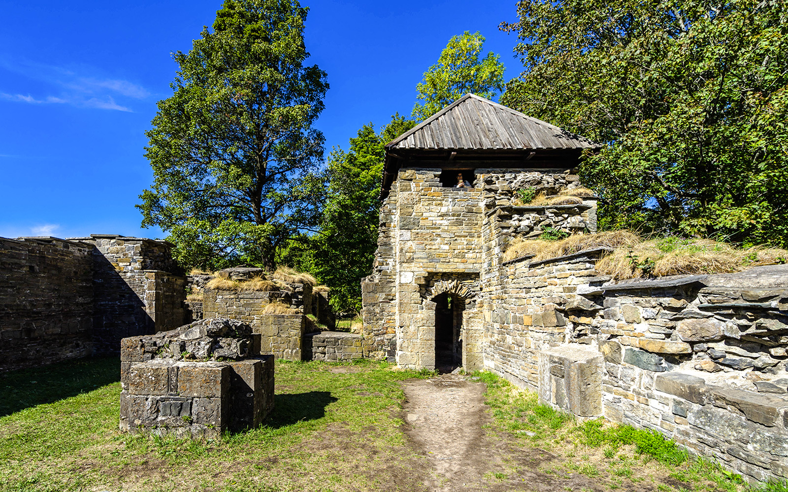 Ruins of the 12th-century Cistercian monastery on Hovedoya Island, surrounded by trees.