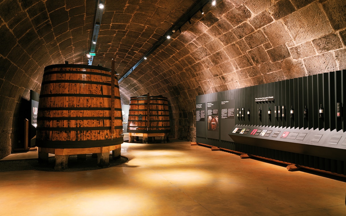 Fonseca port wine cellar with large wooden barrels and informational displays.