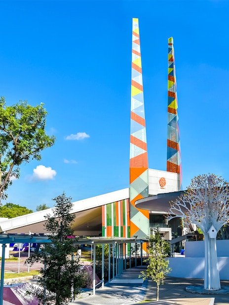 Visitors at Science Centre Singapore with colorful towers and modern architecture.