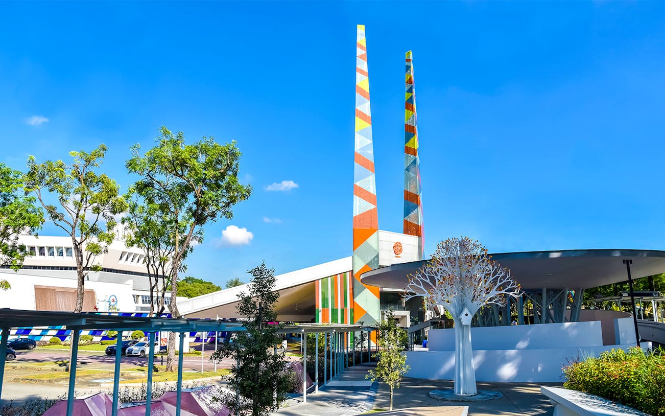 Visitors at Science Centre Singapore with colorful towers and modern architecture.