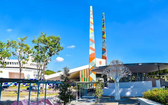 Visitors at Science Centre Singapore with colorful towers and modern architecture.