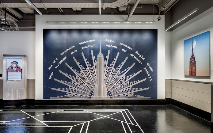 Empire State Building welcome mural with greetings in multiple languages.