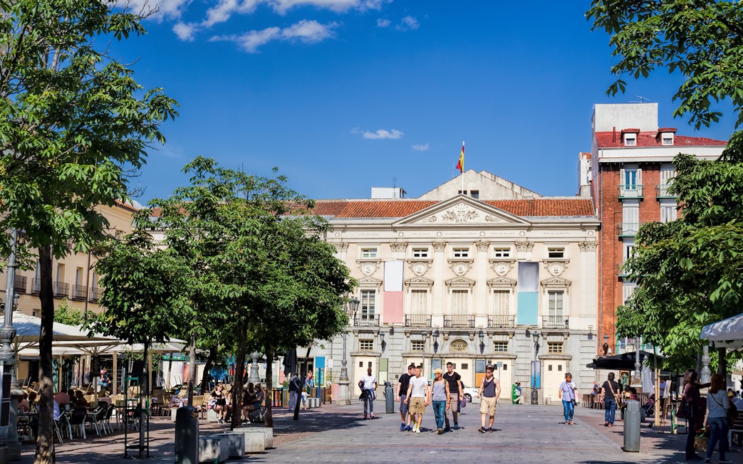 Plaza de Santa Ana in Madrid with people walking and cafes lining the square.