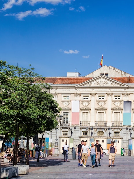 Plaza de Santa Ana in Madrid with people walking and cafes lining the square.