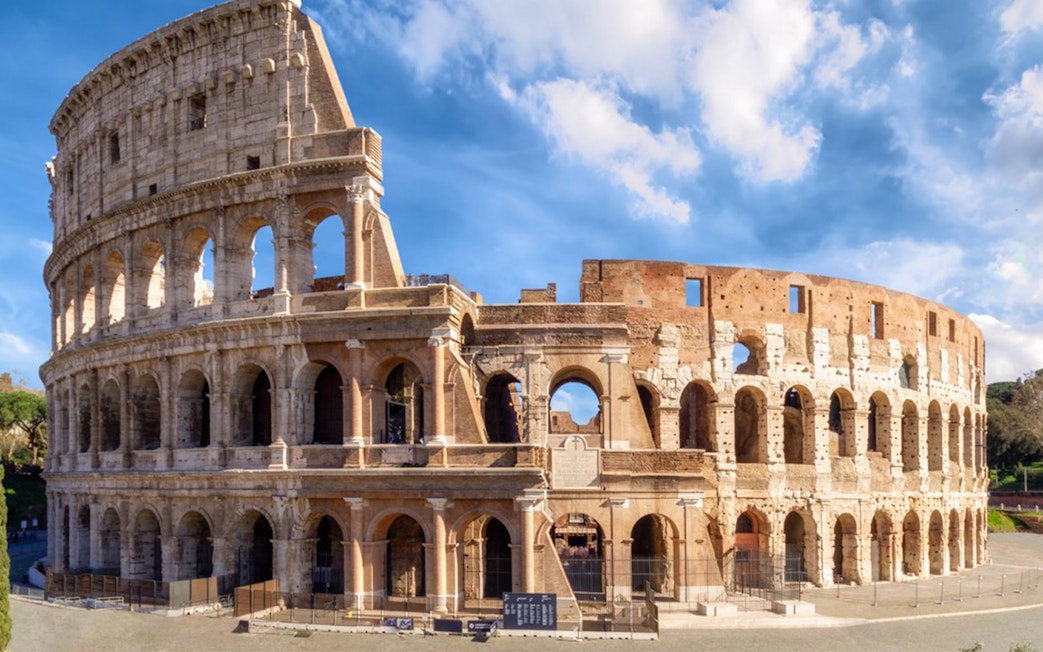 Colosseum in Rome under blue sky, part of skip-the-line tour with virtual reality experience.