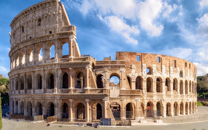 Colosseum in Rome under blue sky, part of skip-the-line tour with virtual reality experience.