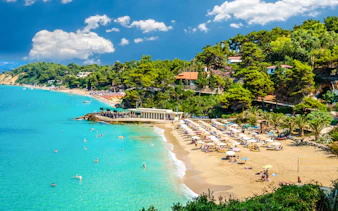 Makris Gialos beach with sunbathers and umbrellas, Argostoli, Kefalonia, Greece.