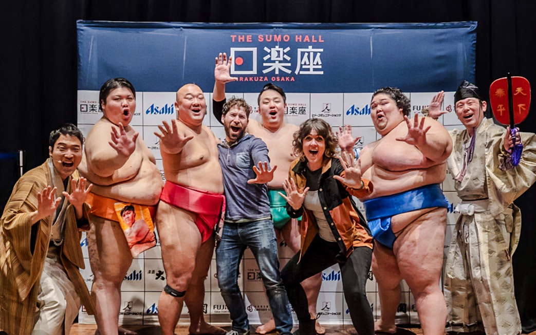 Sumo wrestlers and visitors posing at The Sumo Hall Hirakuza Osaka.