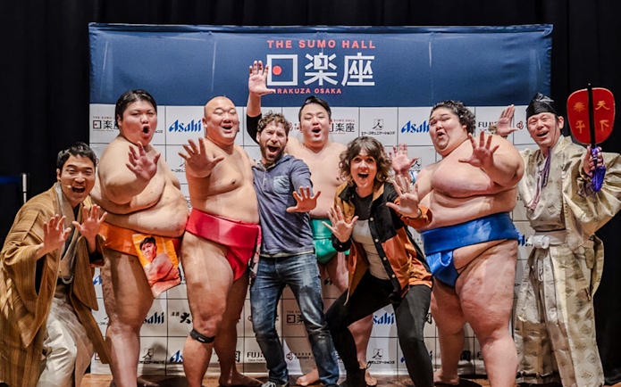 Sumo wrestlers and visitors posing at The Sumo Hall Hirakuza Osaka.