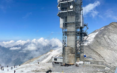 Towering structure on Mt. Titlis with snowy landscape and tourists, Engelberg tour from Lucerne.