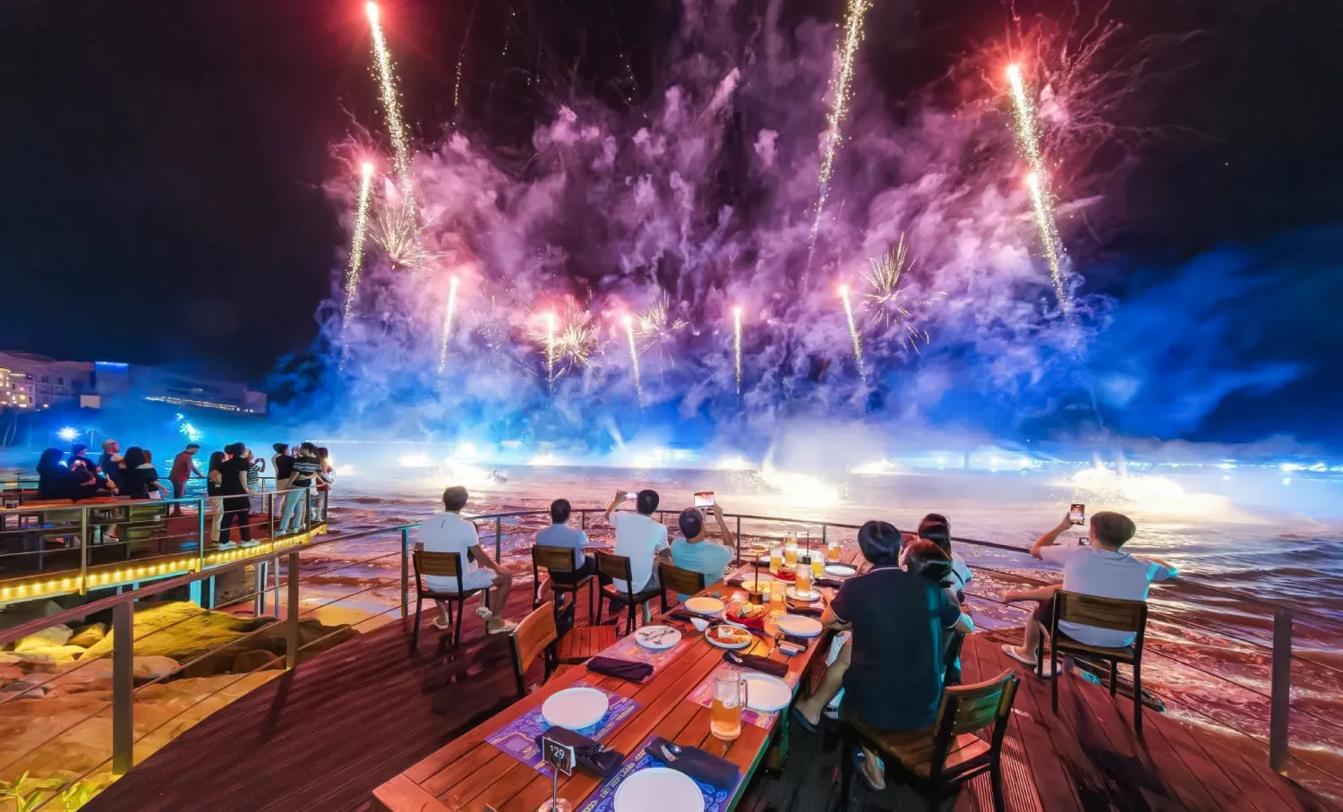 Dinner guests watching fireworks over the sea in Phu Quoc during Symphony of the Sea event.