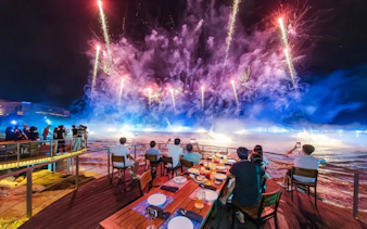 Dinner guests watching fireworks over the sea in Phu Quoc during Symphony of the Sea event.
