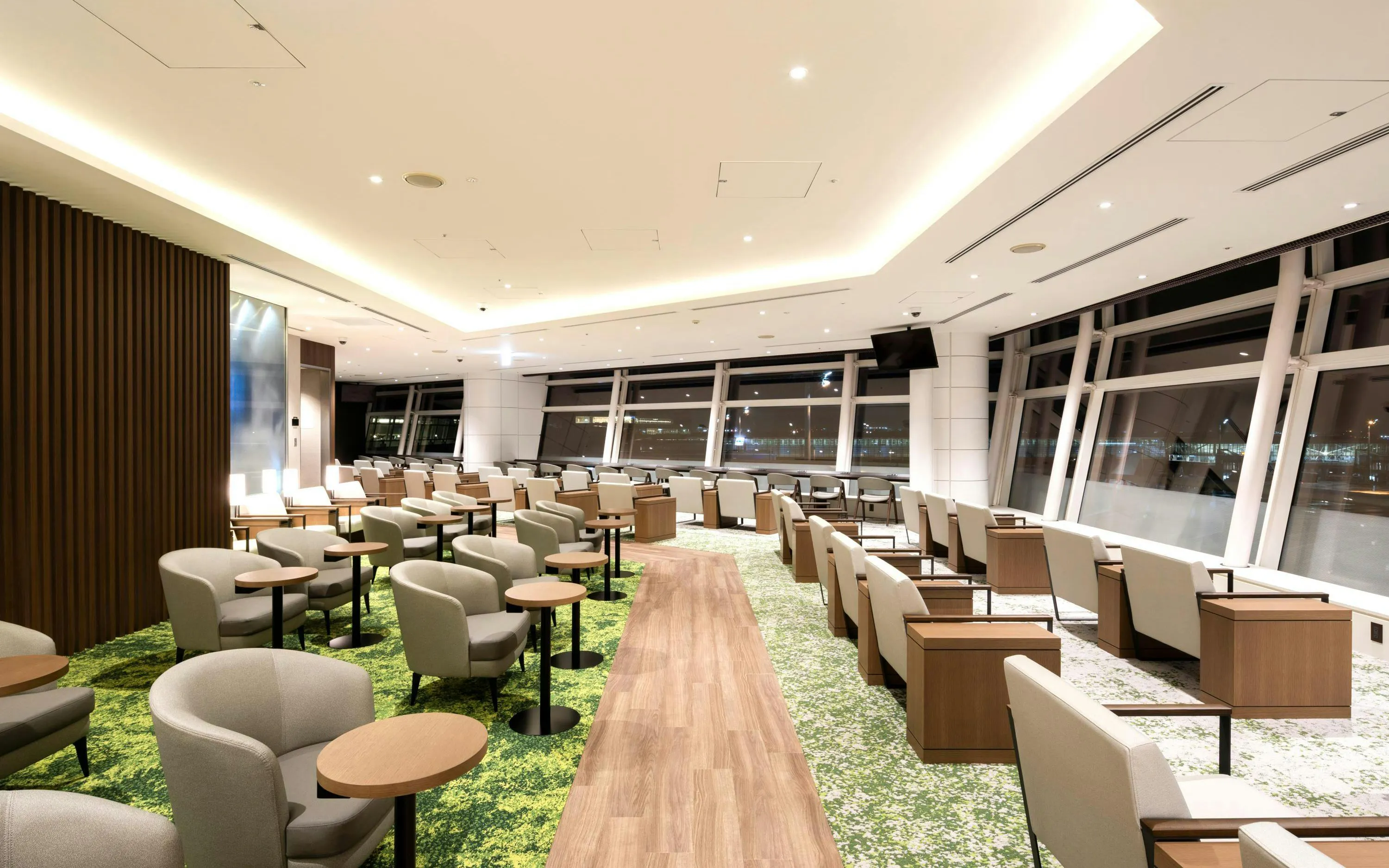 TIAT Lounge seating area at Tokyo International Airport with large windows and modern decor.