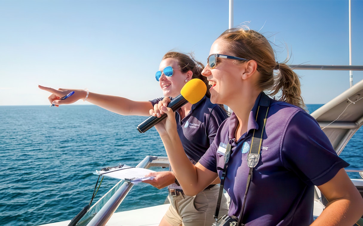 Guides on England Aquarium Whale Watching Cruise pointing at sea.