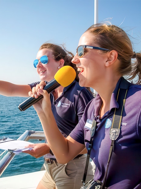 Guides on England Aquarium Whale Watching Cruise pointing at sea.