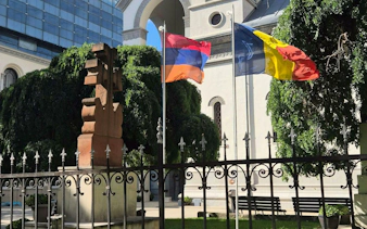 Armenian cross stone and flags in Bucharest's Armenian Quarter.