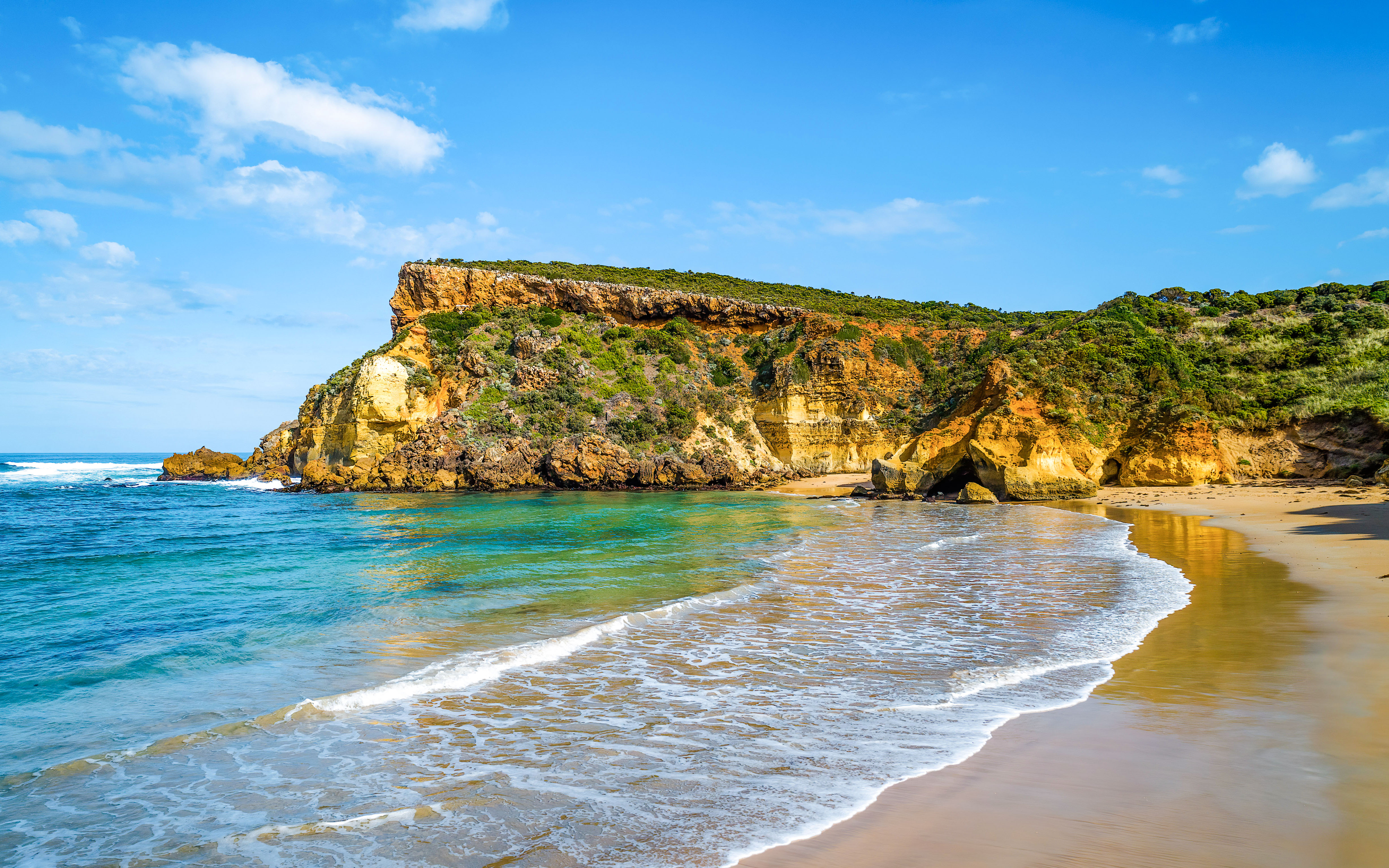 Childers Cove beach along Great Ocean Road, Australia, with waves crashing against cliffs.