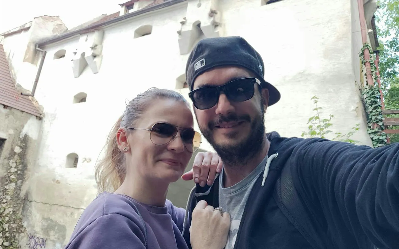 Couple in front of historic building during Brasov self-guided city exploration game.