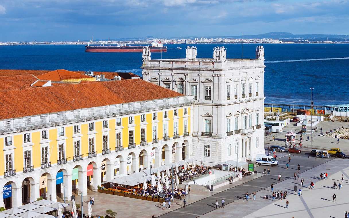 Rua Augusta Arch overlooking Lisbon's waterfront with bustling square below.