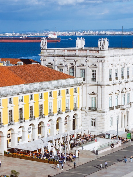 Rua Augusta Arch overlooking Lisbon's waterfront with bustling square below.