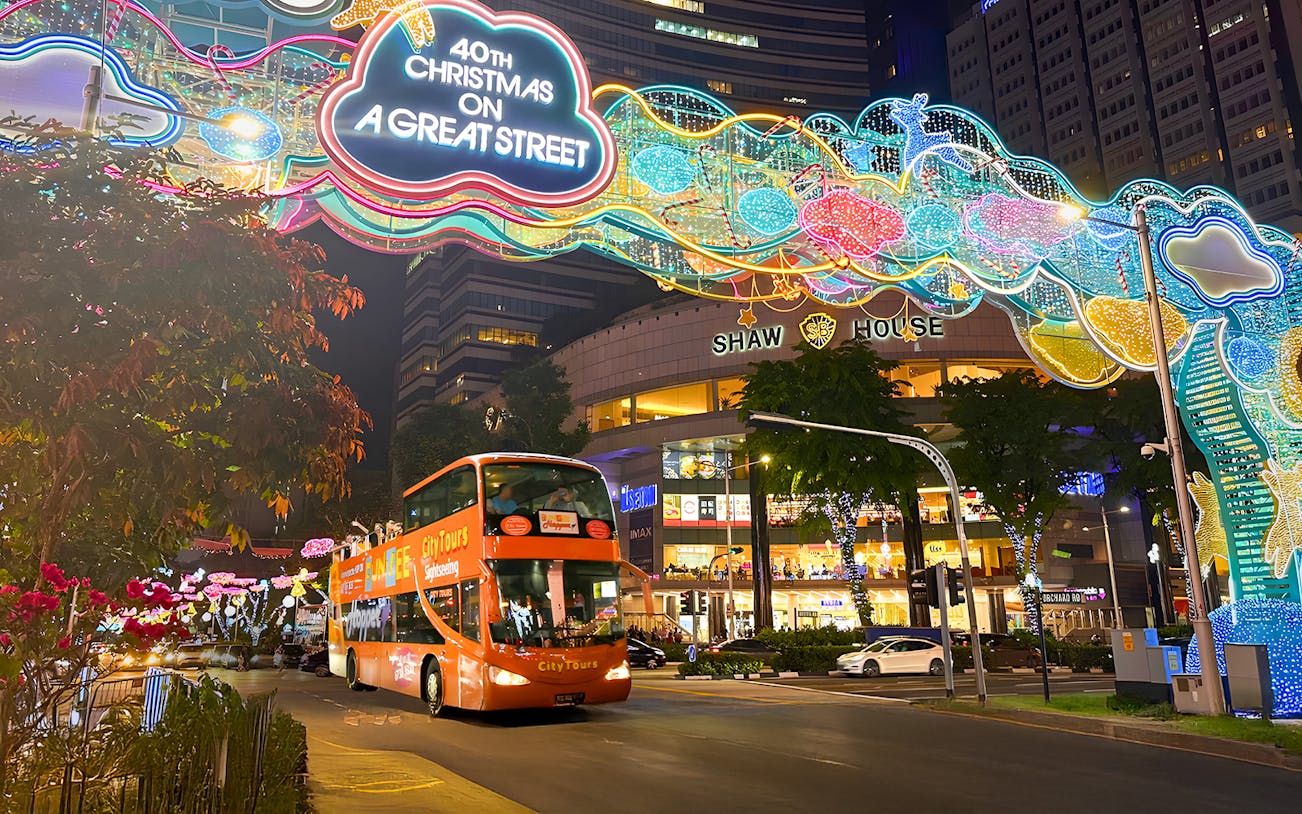 Singapore Christmas lights on Orchard Road with a sightseeing bus passing Shaw House.