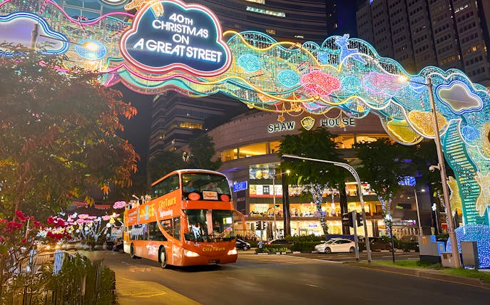 Singapore Christmas lights on Orchard Road with a sightseeing bus passing Shaw House.
