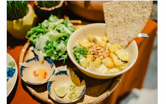 Bowl of Vietnamese street food with herbs and rice crackers, Da Nang food tour.