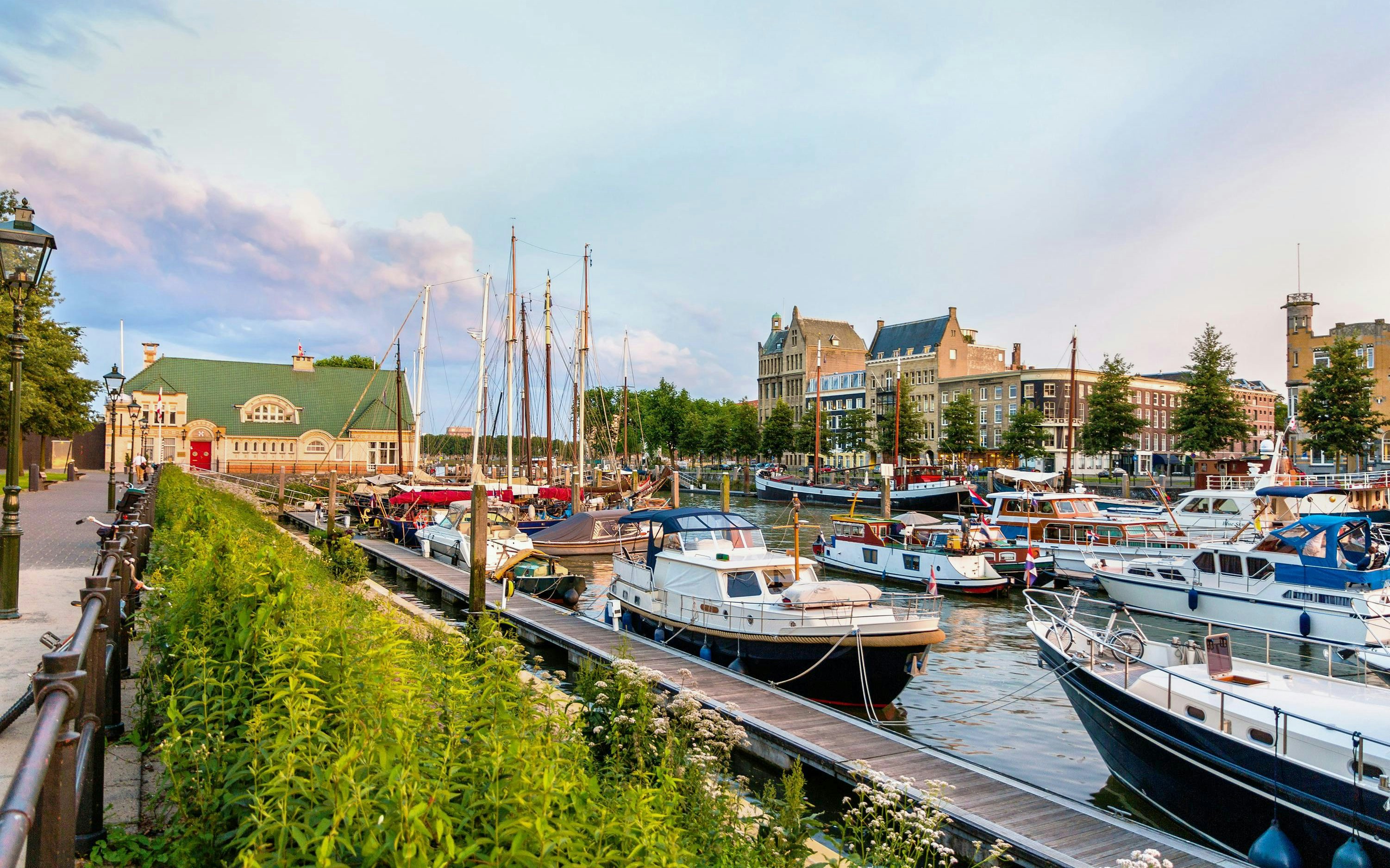 Boats docked at Veerhaven port in Rotterdam, Netherlands, with historic buildings in the background.