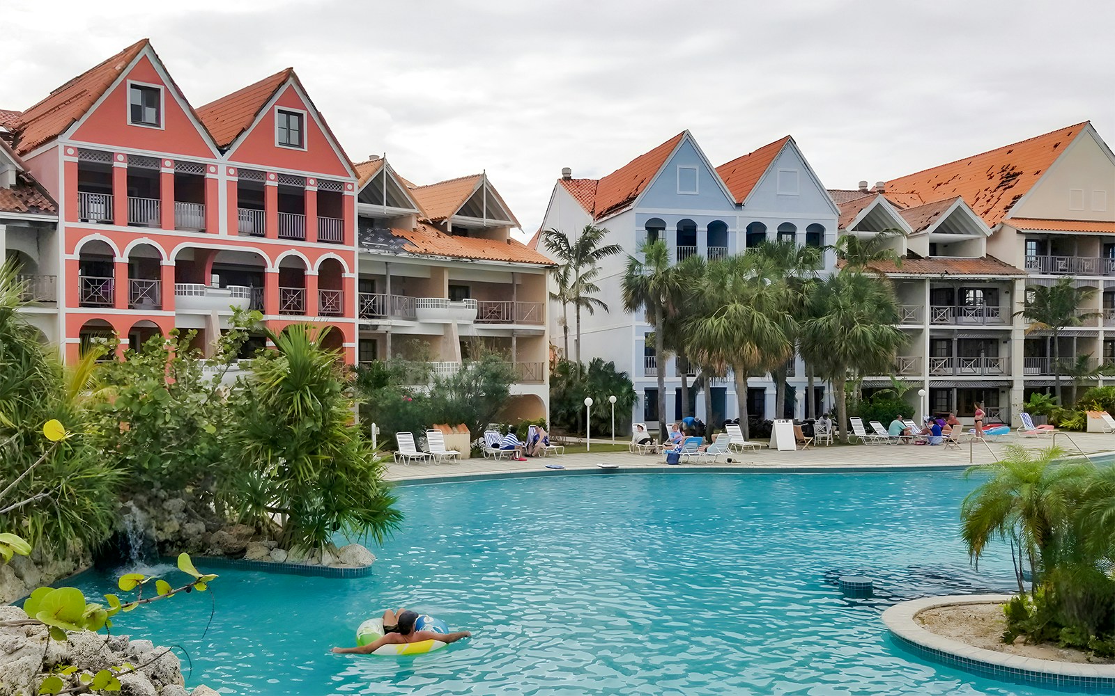 Taino Beach Resort beachfront view with palm trees and clear blue water in Freeport, Bahamas.