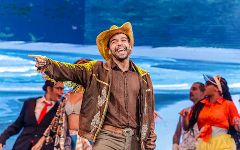 Performer in cowboy hat and jacket leading a samba show at Rio Scenarium, Rio de Janeiro.