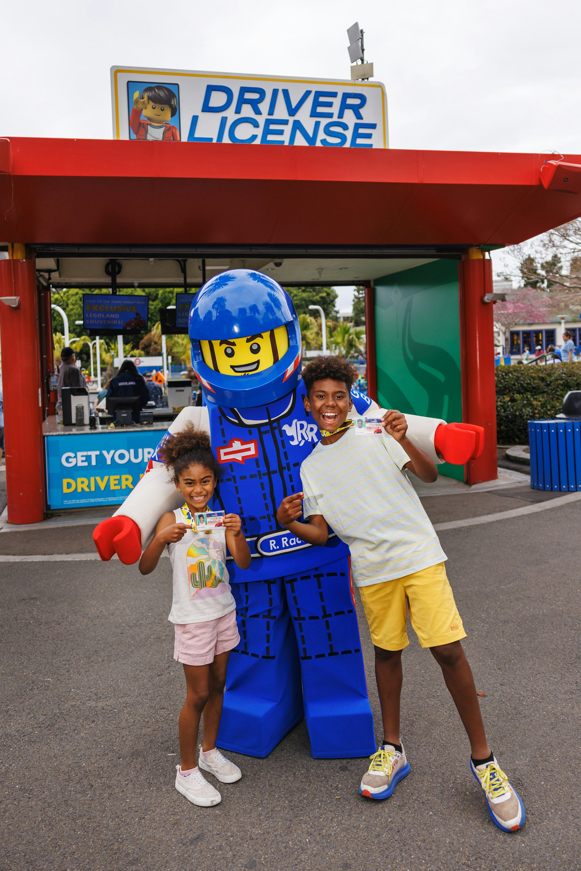 Kids holding LEGO driving licenses with a LEGO character at LEGOLAND® California.