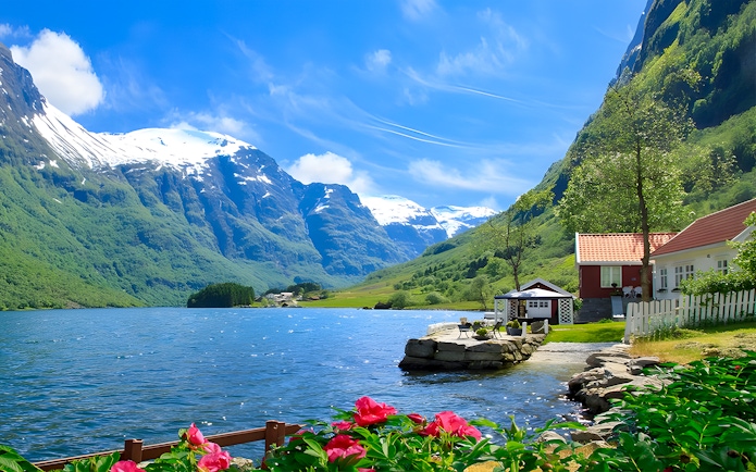 Nærøyfjord with snow-capped mountains, red-roofed house, and vibrant flowers in Norway.
