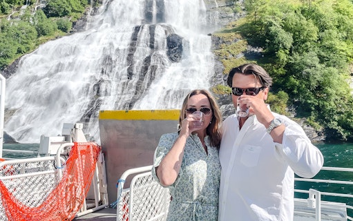 Couple enjoying waterfall tasting on Geiranger Fjord boat tour.